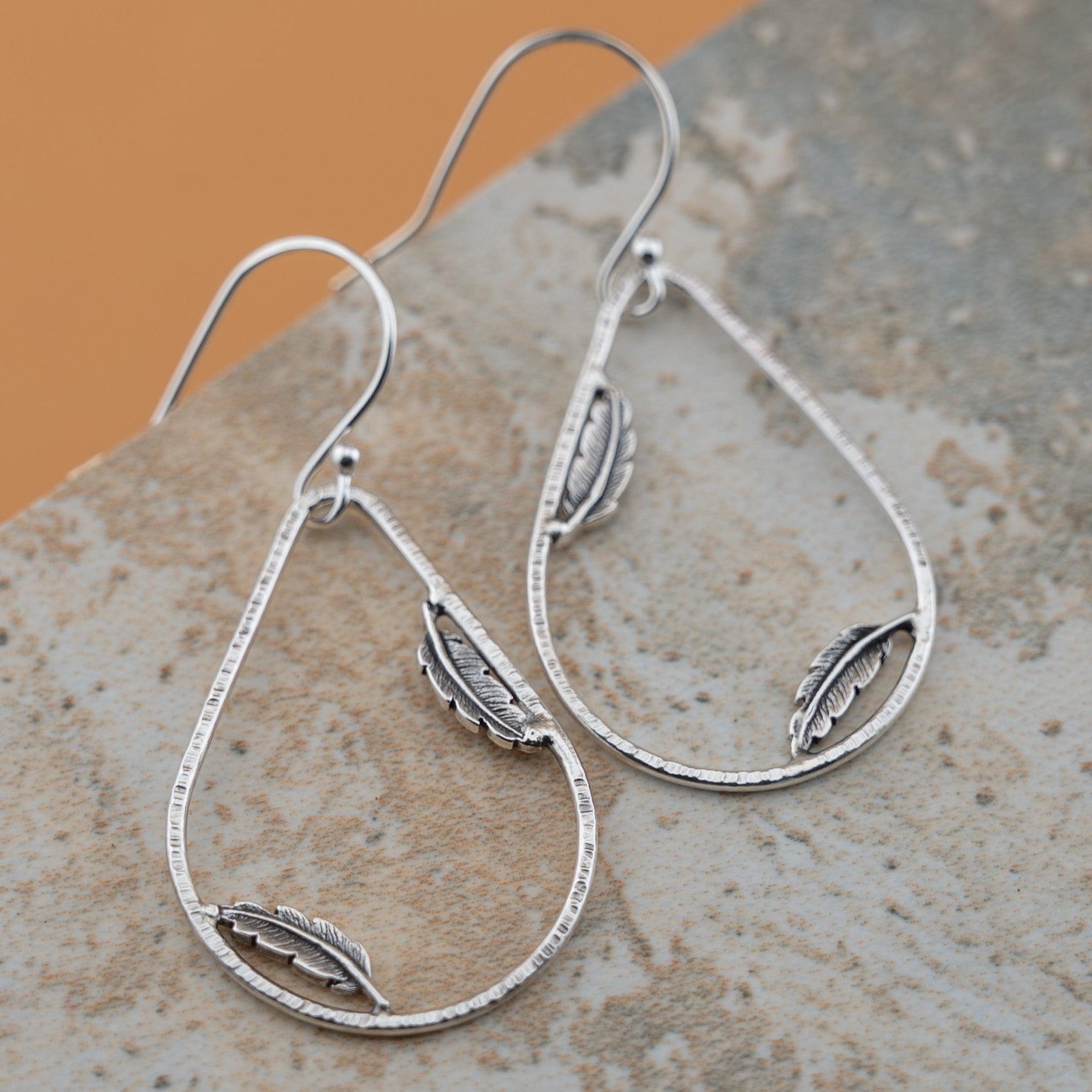 Sterling silver teardrop hoop earrings with dainty feather accents