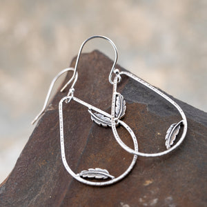 Sterling silver teardrop hoop earrings with dainty feather accents