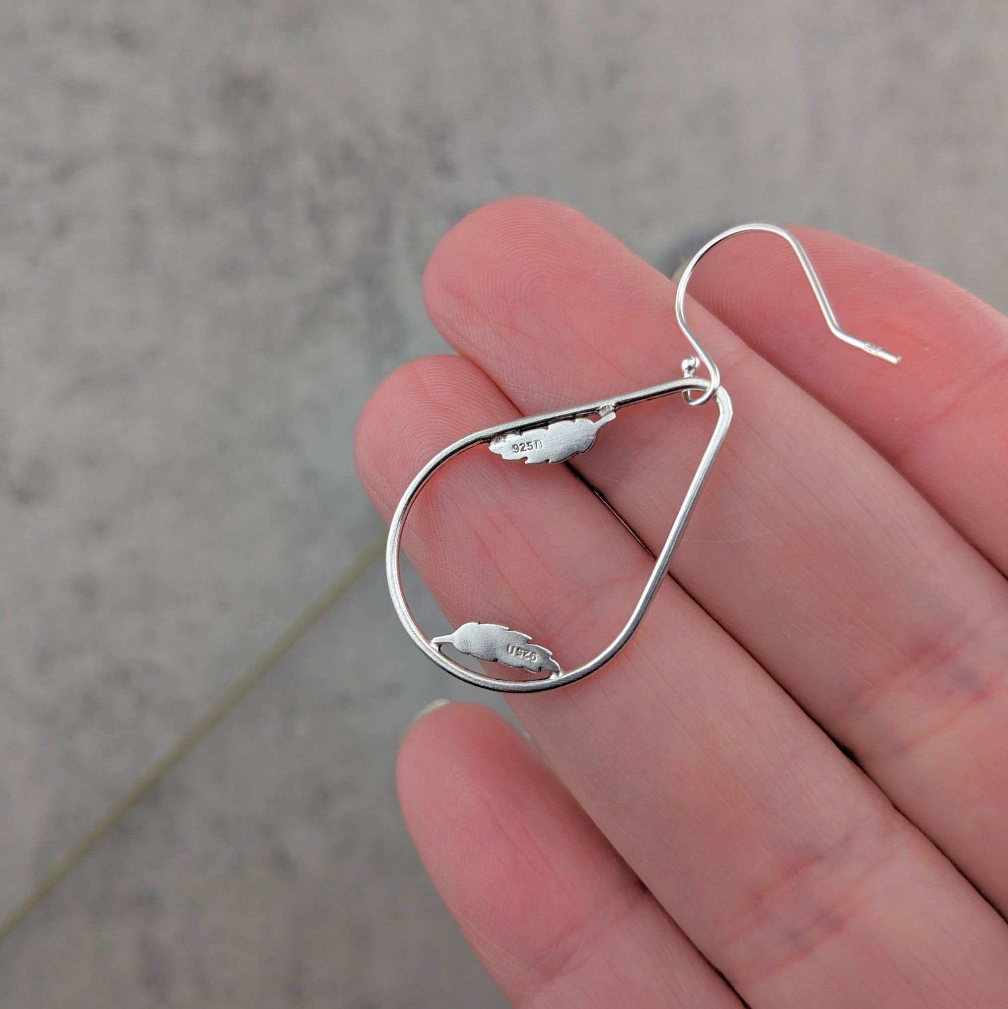 Sterling silver teardrop hoop earrings with dainty feather accents